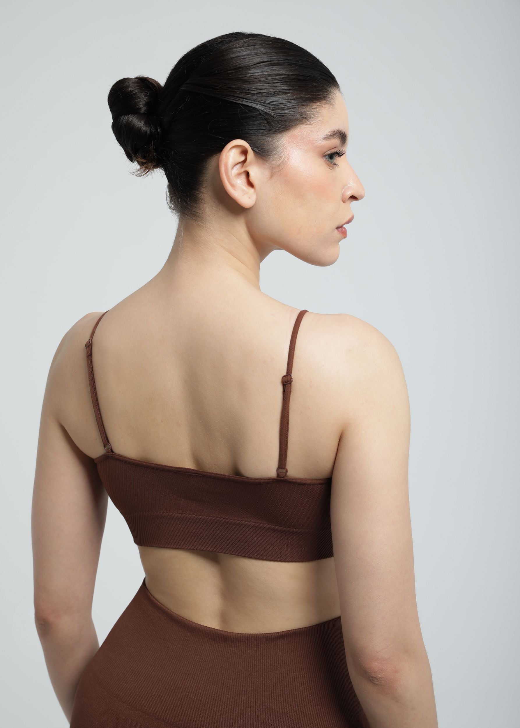Model wearing Second Skin Essential Sculpting Bralette in cocoa brown, back studio view